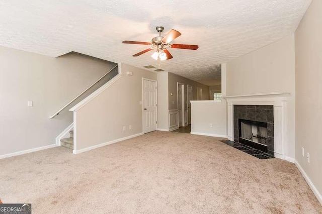 2838 Vining Ridge Ter Unit 0, Decatur, GA 30034 - unfurnished living room featuring a textured ceiling, ceiling fan, carpet, stairway, and a tiled fireplace