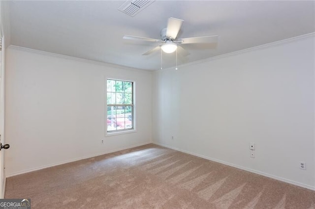 unfurnished room featuring ornamental molding, carpet floors, a ceiling fan, and baseboards