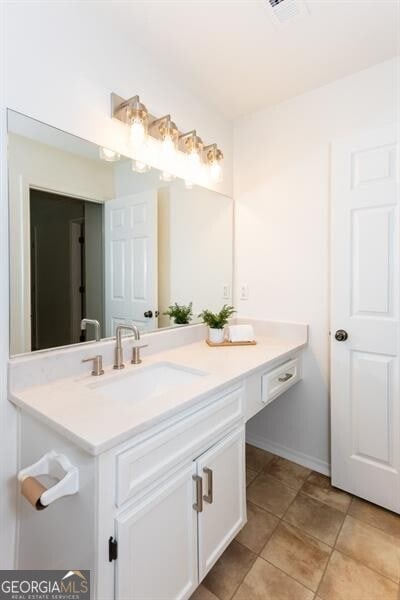 bathroom with vanity, tile patterned floors, and baseboards