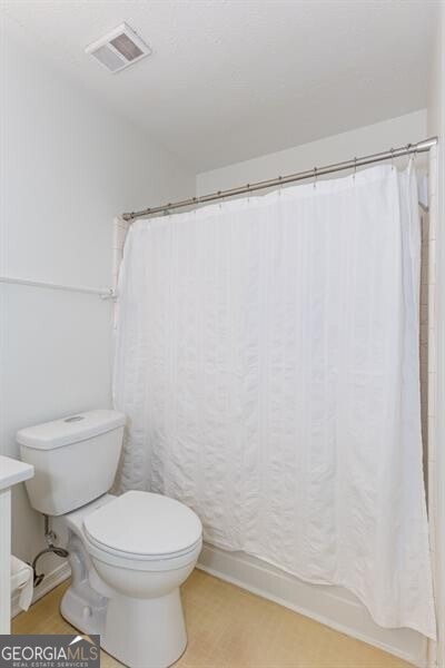 full bathroom featuring toilet, baseboards, and wood finished floors