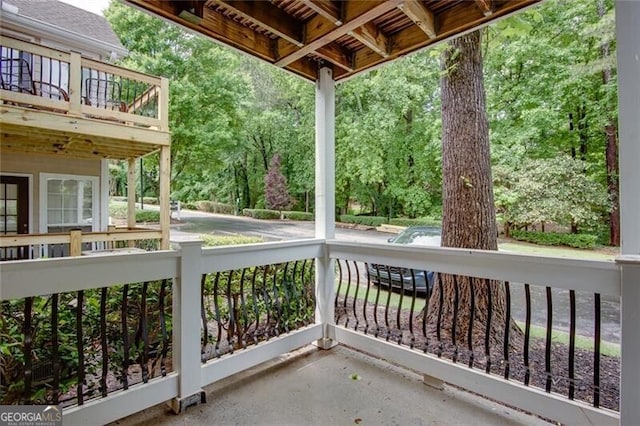 view of patio / terrace with a balcony and view of wooded area