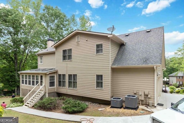 4002 Turnstone Dr NW, Kennesaw, GA 30152 - rear view of property with central AC, a chimney, a shingled roof, and stairs