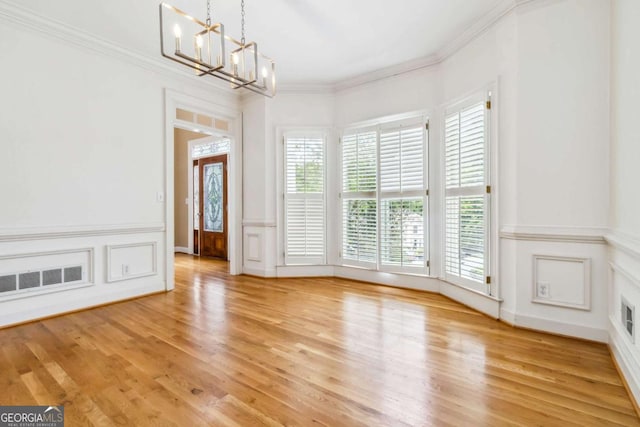 4002 Turnstone Dr NW, Kennesaw, GA 30152 - unfurnished dining area with a chandelier, crown molding, healthy amount of natural light, a decorative wall, and light wood-type flooring