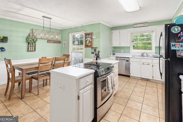 139 Heath Dr S, Macon, GA 31220 - kitchen with appliances with stainless steel finishes, a center island, white cabinets, light tile patterned floors, and a textured ceiling