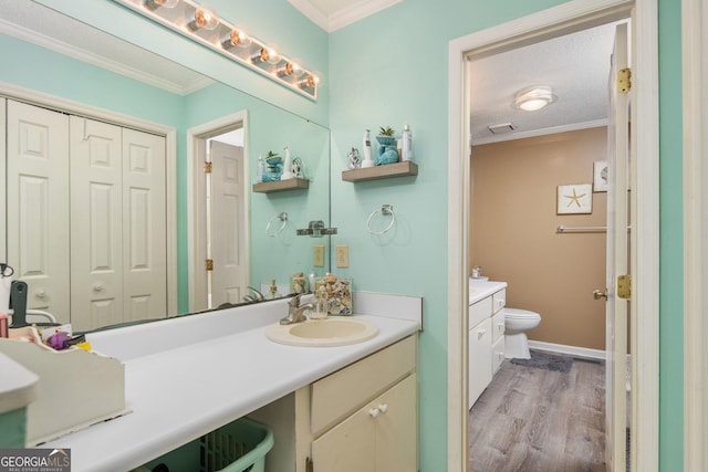 139 Heath Dr S, Macon, GA 31220 - bathroom featuring vanity, toilet, wood finished floors, ornamental molding, and baseboards