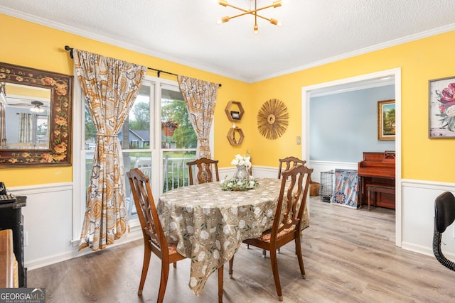 139 Heath Dr S, Macon, GA 31220 - dining area featuring a wainscoted wall, wood finished floors, ornamental molding, a chandelier, and a textured ceiling