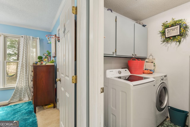 139 Heath Dr S, Macon, GA 31220 - clothes washing area featuring cabinet space, a textured ceiling, washing machine and clothes dryer, and light colored carpet