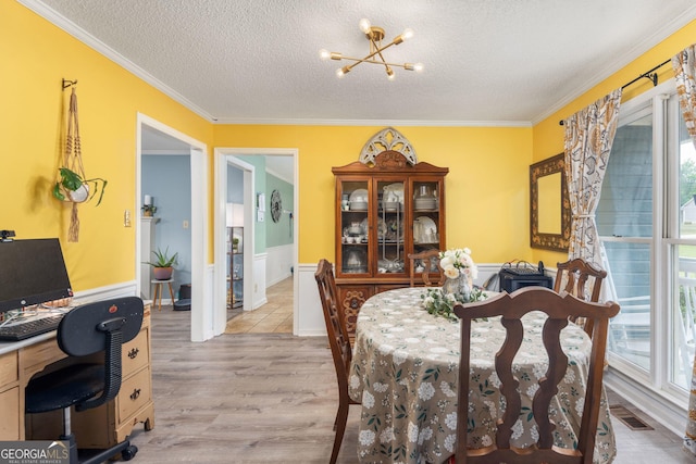 139 Heath Dr S, Macon, GA 31220 - dining area featuring a chandelier, light wood finished floors, healthy amount of natural light, crown molding, and a textured ceiling