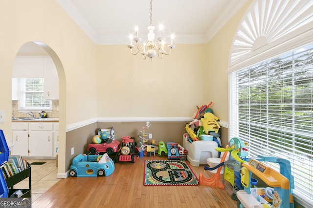 11 Vintage Ct SW, Cartersville, GA 30120 - rec room with a chandelier, light wood-type flooring, ornamental molding, arched walkways, and a sink
