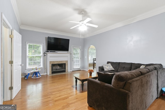 11 Vintage Ct SW, Cartersville, GA 30120 - living area featuring arched walkways, a ceiling fan, light wood-style flooring, a tile fireplace, and ornamental molding
