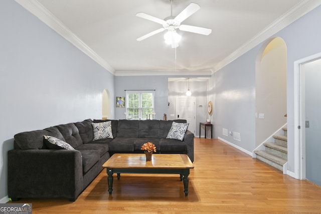 11 Vintage Ct SW, Cartersville, GA 30120 - living room featuring arched walkways, light wood finished floors, a ceiling fan, ornamental molding, and stairs