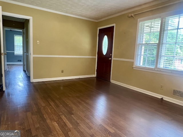 entrance foyer featuring dark wood finished floors, baseboards, crown molding, and a textured ceiling