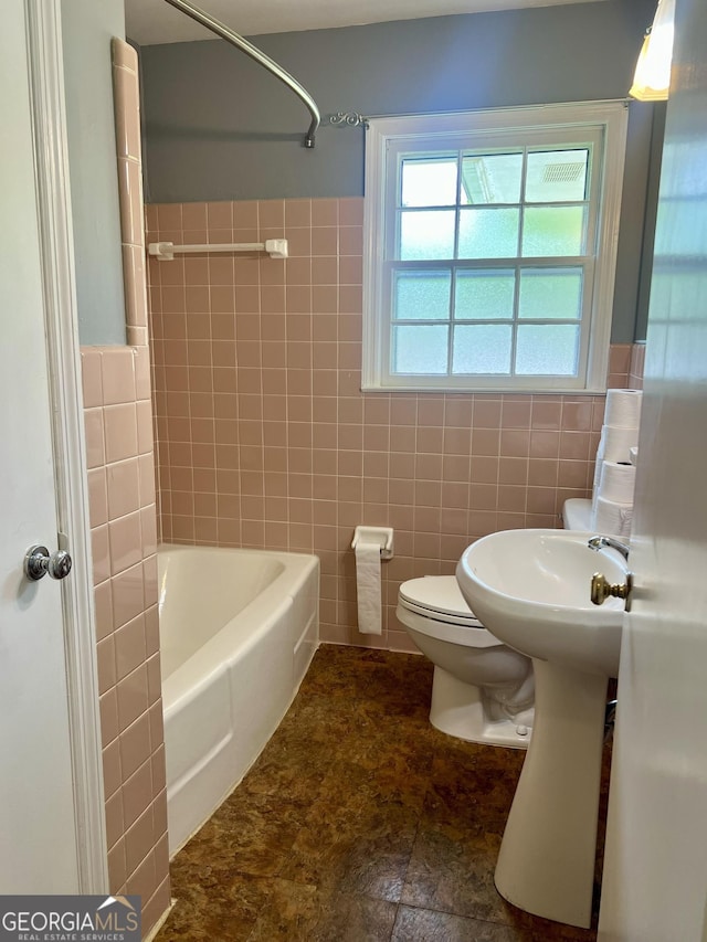 bathroom with tile walls, toilet, and bathing tub / shower combination