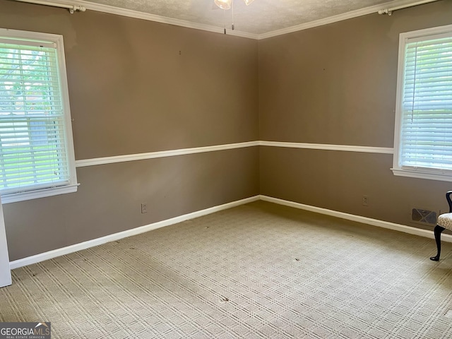 spare room featuring ornamental molding, carpet floors, baseboards, and ceiling fan