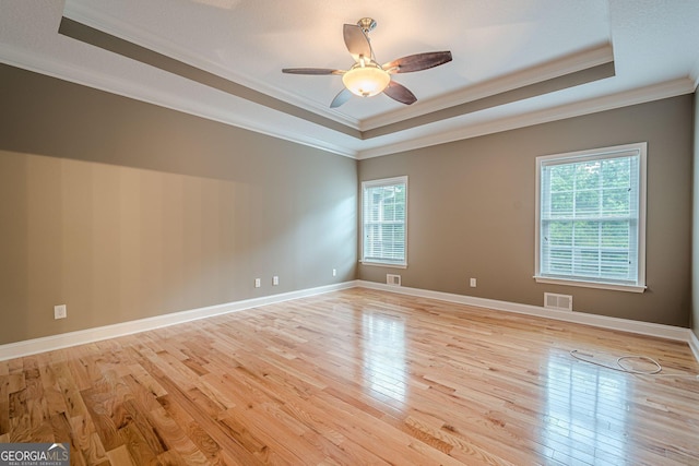 516 Main St, Hiram, GA 30141 - empty room with a raised ceiling, ornamental molding, healthy amount of natural light, light wood-style floors, and a ceiling fan