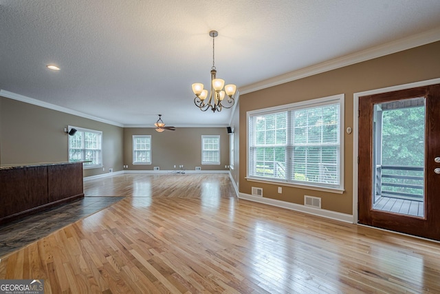 516 Main St, Hiram, GA 30141 - unfurnished living room featuring a chandelier, crown molding, wood finished floors, baseboards, and a textured ceiling
