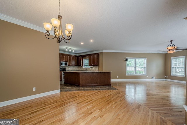 516 Main St, Hiram, GA 30141 - kitchen featuring stainless steel appliances, open floor plan, ornamental molding, light wood-style flooring, and baseboards