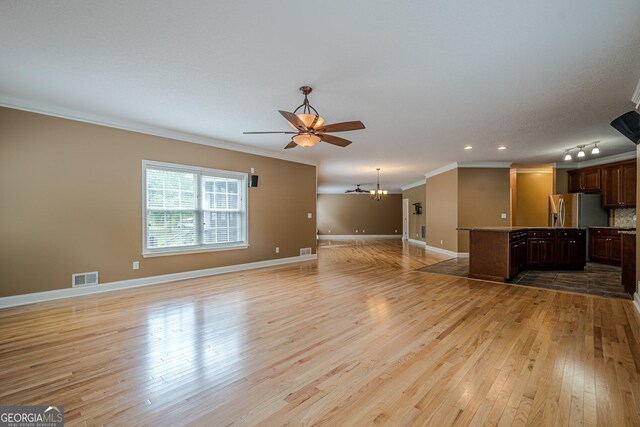 516 Main St, Hiram, GA 30141 - unfurnished living room with ornamental molding, a ceiling fan, light wood finished floors, a chandelier, and baseboards