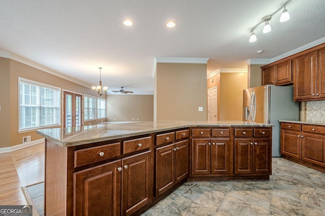 516 Main St, Hiram, GA 30141 - kitchen featuring stainless steel fridge with ice dispenser, crown molding, a chandelier, light countertops, and a kitchen island
