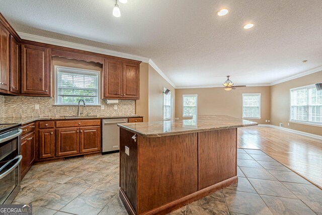 516 Main St, Hiram, GA 30141 - kitchen featuring appliances with stainless steel finishes, a sink, crown molding, healthy amount of natural light, and a kitchen island
