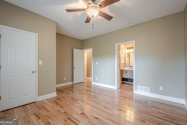 516 Main St, Hiram, GA 30141 - unfurnished bedroom featuring light wood-style flooring, baseboards, connected bathroom, and a ceiling fan