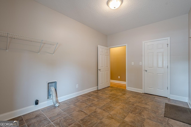516 Main St, Hiram, GA 30141 - laundry area with baseboards, stone finish flooring, and a textured ceiling