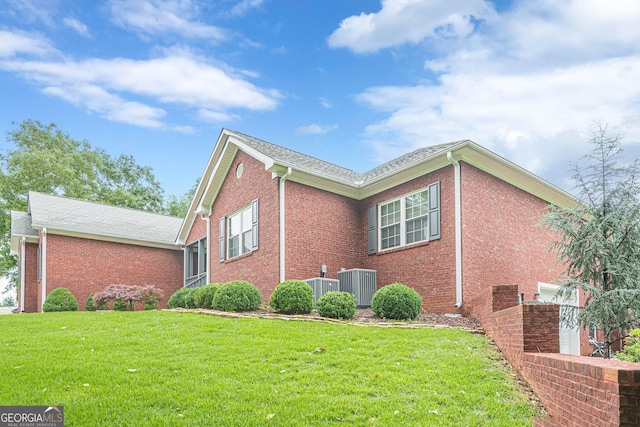 516 Main St, Hiram, GA 30141 - view of home's exterior featuring brick siding, a yard, and central air condition unit