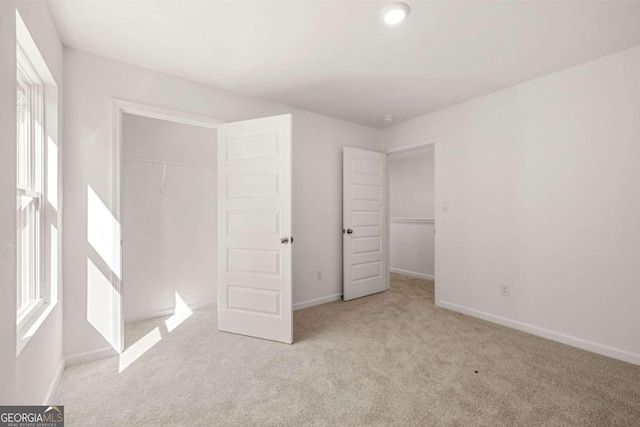 unfurnished bedroom with carpet, a closet, and baseboards