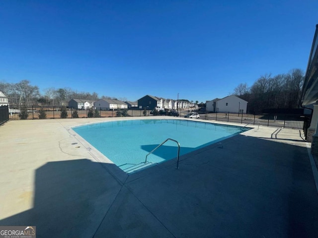 community pool with fence and a patio area