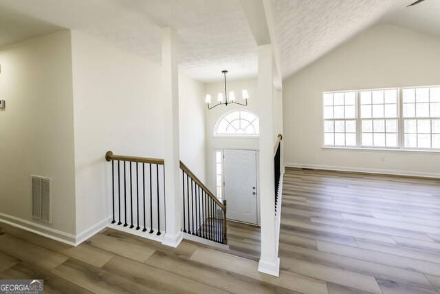 2192 Stenger Rd, Douglasville, GA 30135 - foyer entrance featuring a textured ceiling, healthy amount of natural light, wood finished floors, lofted ceiling, and a chandelier