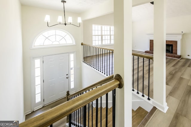 2192 Stenger Rd, Douglasville, GA 30135 - foyer entrance featuring plenty of natural light, a chandelier, wood finished floors, a brick fireplace, and a towering ceiling