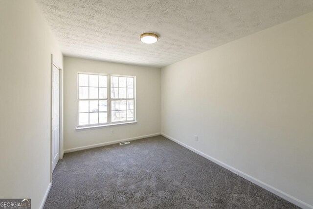 2192 Stenger Rd, Douglasville, GA 30135 - unfurnished room featuring dark colored carpet, baseboards, and a textured ceiling