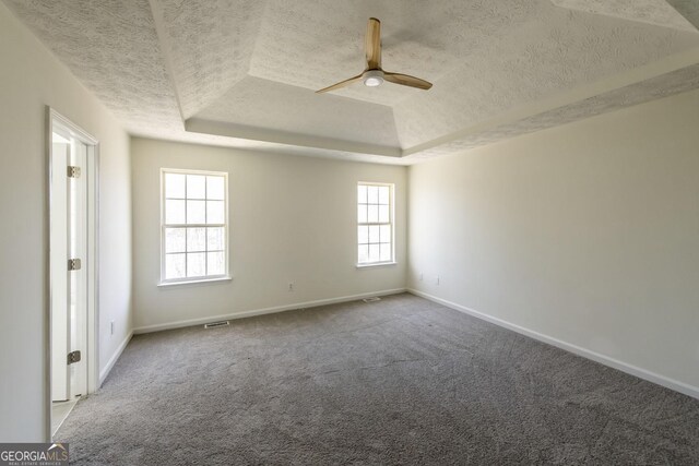2192 Stenger Rd, Douglasville, GA 30135 - carpeted spare room with a textured ceiling, a tray ceiling, healthy amount of natural light, ceiling fan, and baseboards