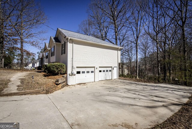 2192 Stenger Rd, Douglasville, GA 30135 - view of home's exterior featuring a garage, driveway, and a shingled roof