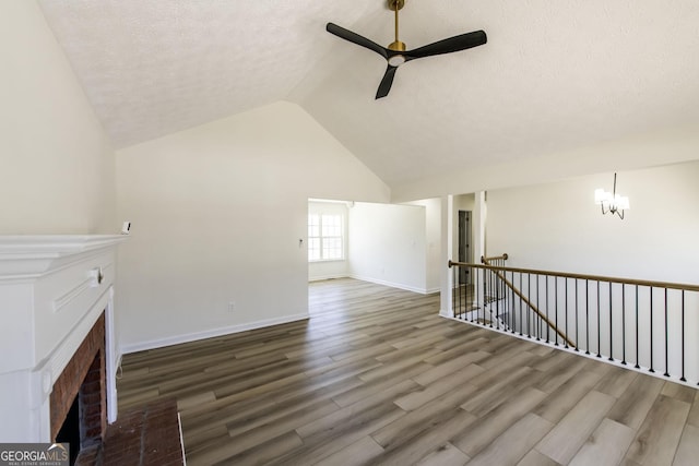 2192 Stenger Rd, Douglasville, GA 30135 - unfurnished living room featuring a fireplace, a ceiling fan, a textured ceiling, wood finished floors, and baseboards