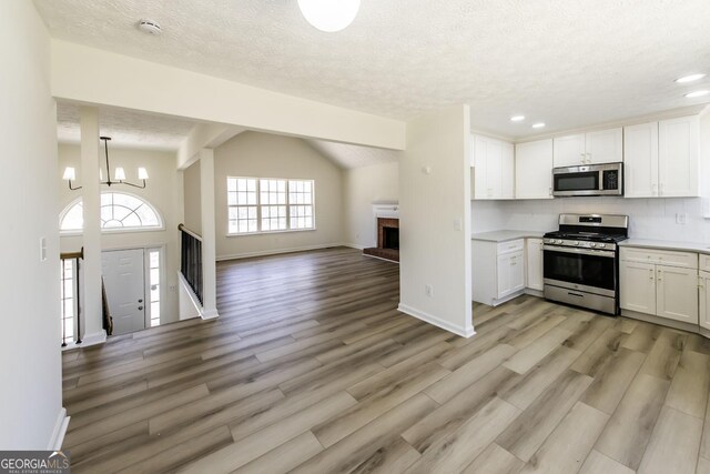 2192 Stenger Rd, Douglasville, GA 30135 - kitchen with stainless steel appliances, open floor plan, light countertops, a chandelier, and white cabinets