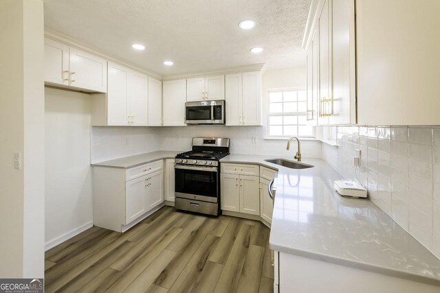2192 Stenger Rd, Douglasville, GA 30135 - kitchen with stainless steel appliances, a sink, white cabinetry, tasteful backsplash, and recessed lighting