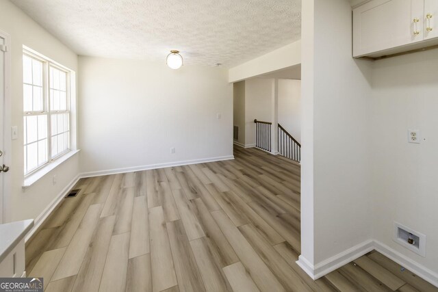 2192 Stenger Rd, Douglasville, GA 30135 - unfurnished dining area with light wood-style flooring, a textured ceiling, and baseboards