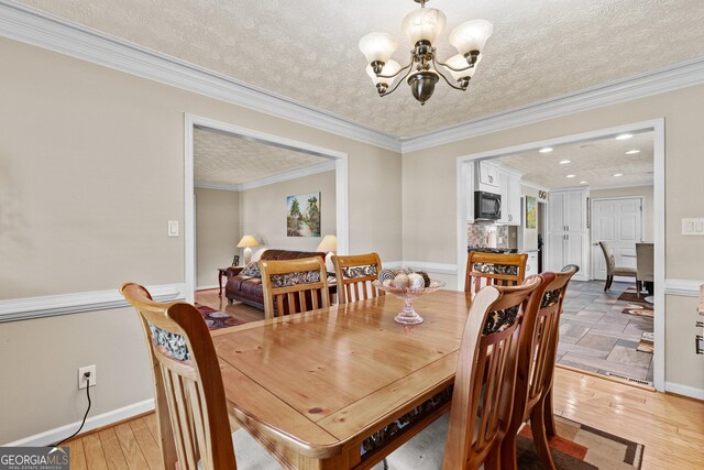 4010 Hamilton Mill Rd, Buford, GA 30519 - dining room featuring a chandelier, a textured ceiling, ornamental molding, light wood-style flooring, and recessed lighting