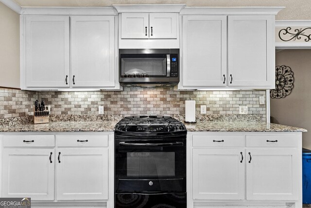 4010 Hamilton Mill Rd, Buford, GA 30519 - kitchen with black range with gas stovetop, stainless steel microwave, white cabinets, backsplash, and light stone counters