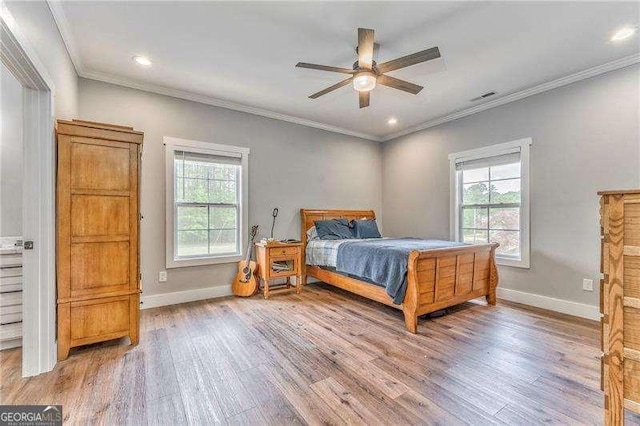 bedroom with multiple windows, light wood-style flooring, baseboards, crown molding, and recessed lighting