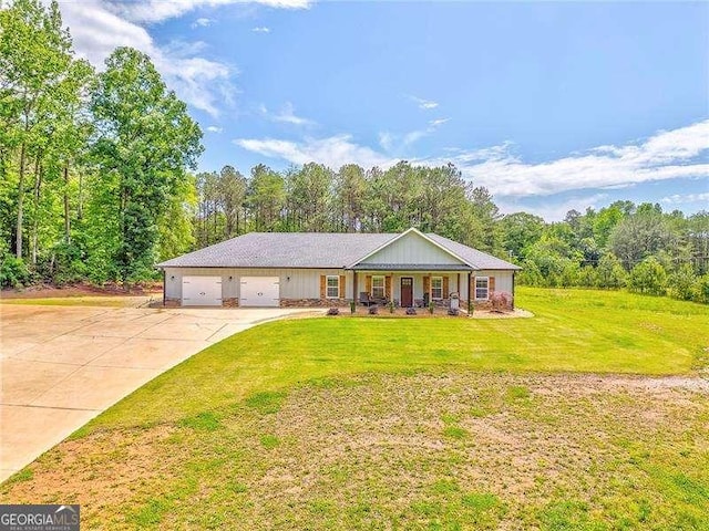 view of front of house featuring concrete driveway, a front lawn, a porch, a garage, and a view of trees