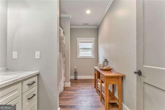 full bath with crown molding, vanity, wood finished floors, and baseboards