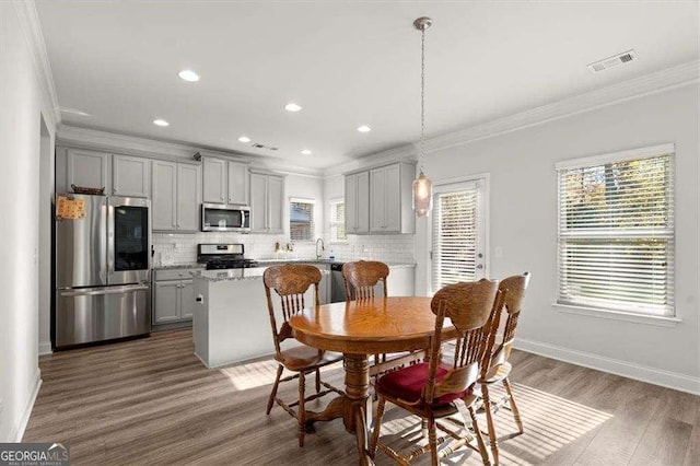 1511 Arica Ave, Lawrenceville, GA 30043 - dining space with crown molding, wood finished floors, baseboards, and recessed lighting