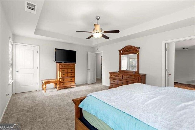 1511 Arica Ave, Lawrenceville, GA 30043 - carpeted bedroom with a tray ceiling, baseboards, and ceiling fan