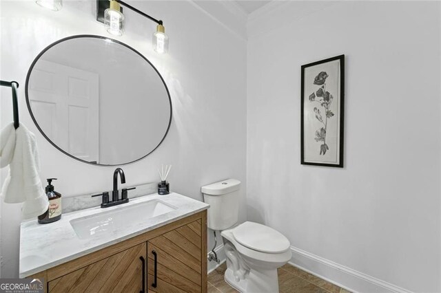 bathroom featuring vanity, toilet, baseboards, and tile patterned floors