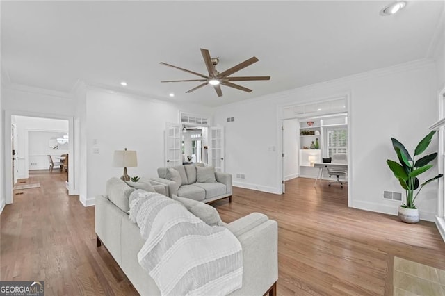living area featuring ceiling fan, crown molding, wood finished floors, recessed lighting, and baseboards