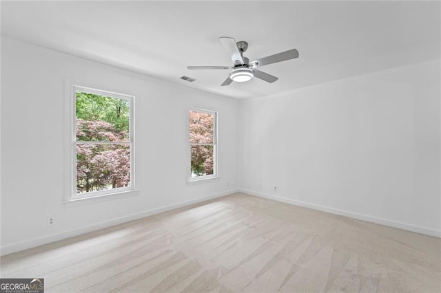 unfurnished room featuring light colored carpet, baseboards, and a ceiling fan