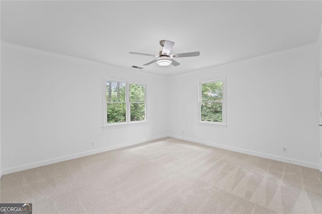 spare room with light carpet, baseboards, and ceiling fan