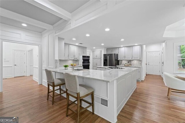 kitchen featuring black appliances, a breakfast bar, recessed lighting, a peninsula, and backsplash